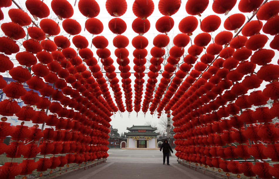 217618 a woman walks past red lanterns which were put up as decoration for an      